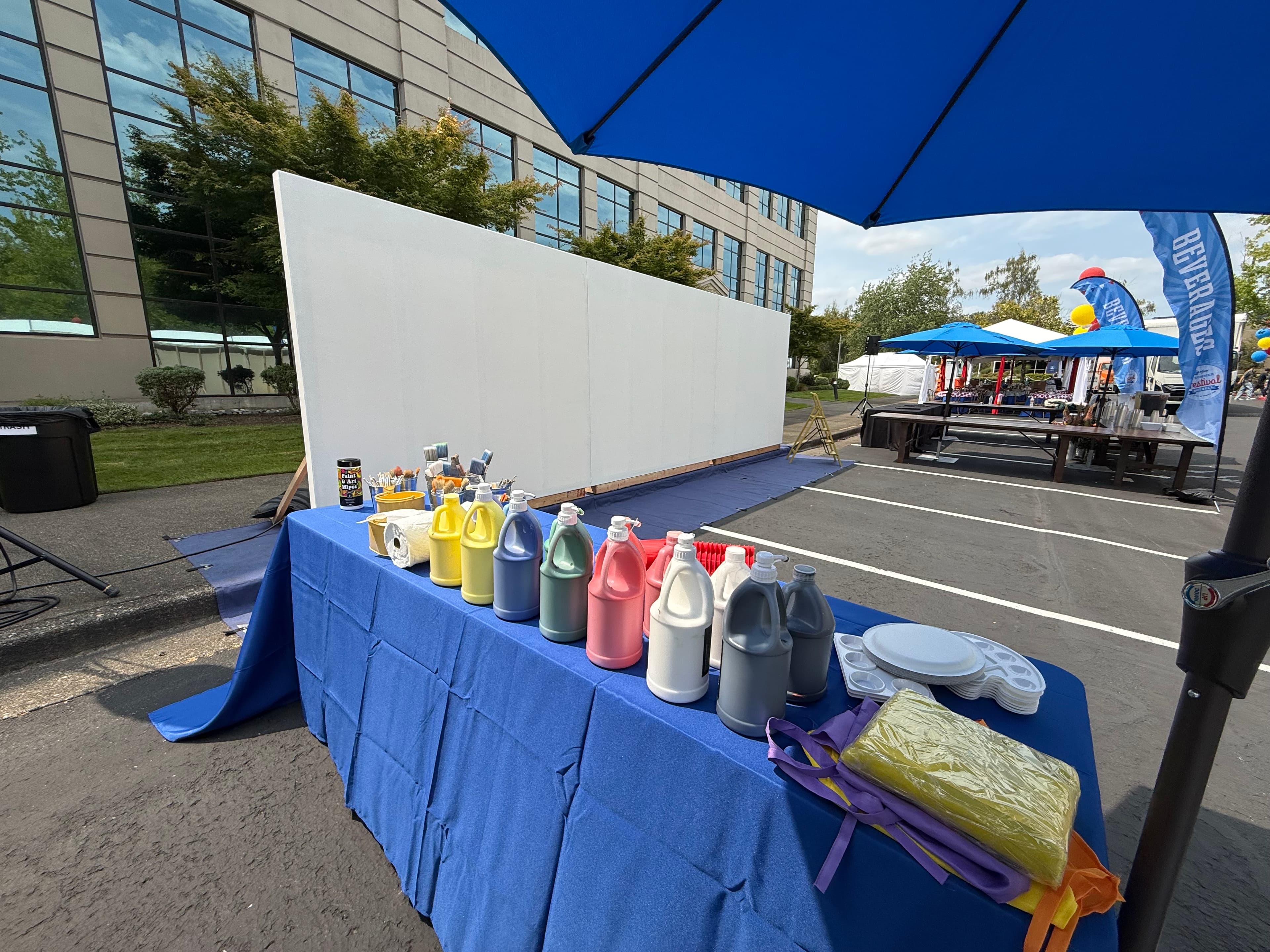 Large blank canvas wall and painting supplies prepared for an outdoor art experience